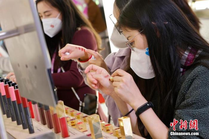 圖為女生正在體驗口紅產(chǎn)品。 殷立勤 攝