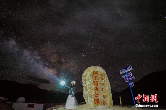 圖為6月20日晚，游客“打卡”西藏阿里暗夜公園，天上是銀河與流星（右上角）。曹枝清 攝